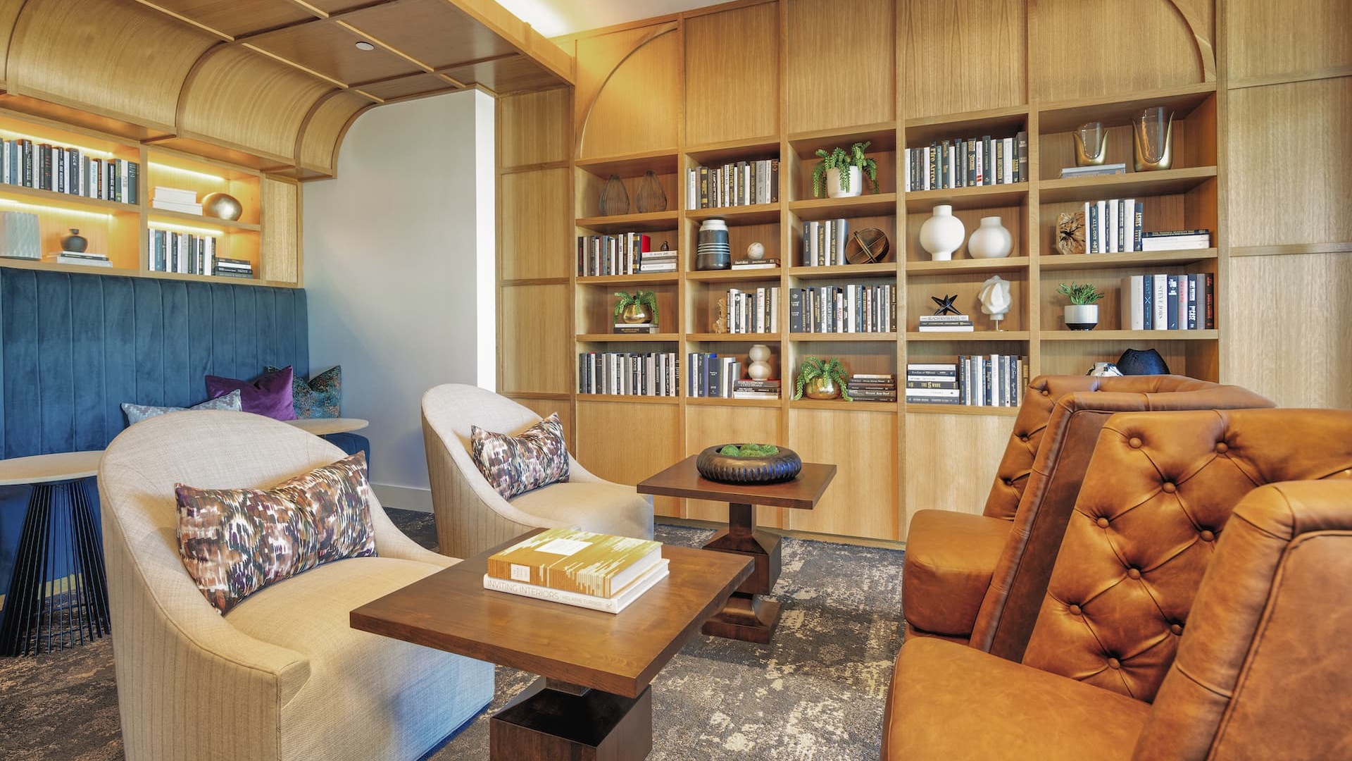 clubhouse with spacious seating, wall of books, ample lighting and custom room accents