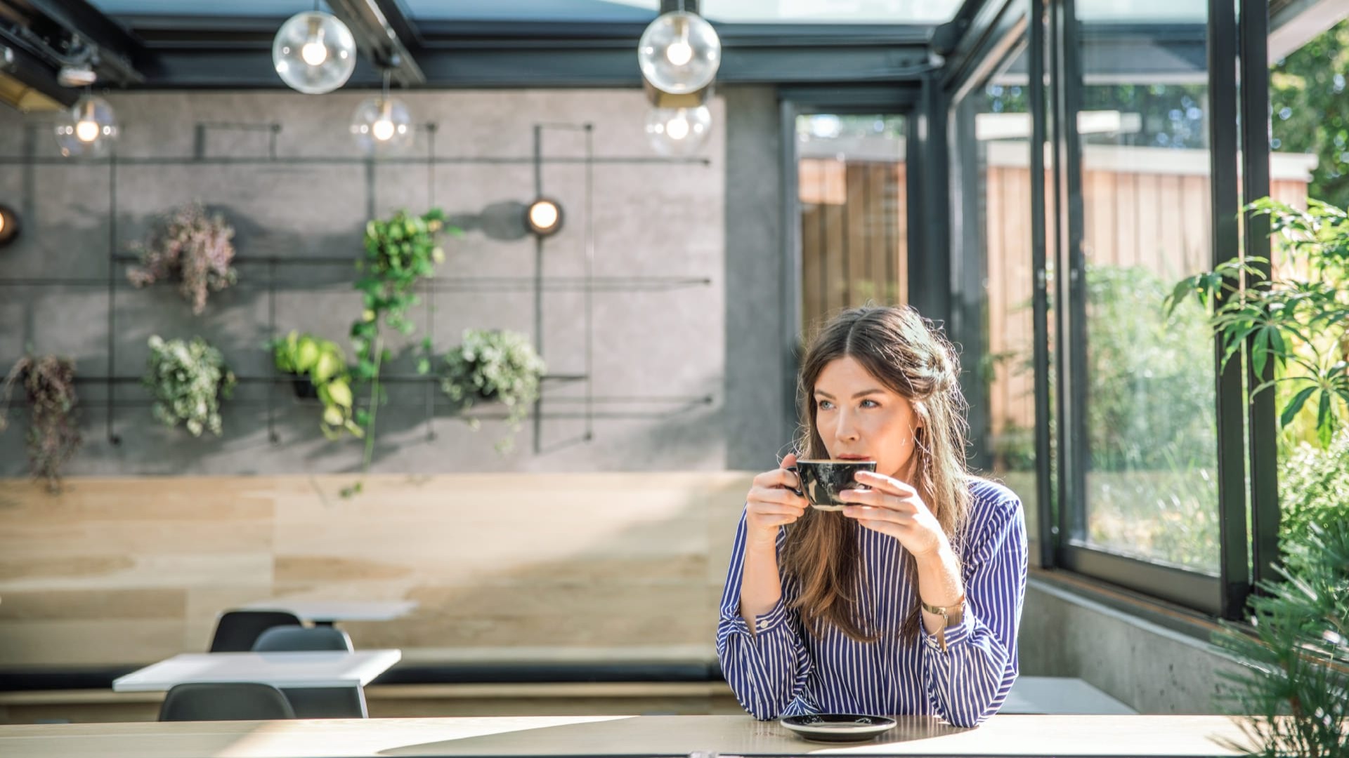 Woman drinking tea in a lush cafe