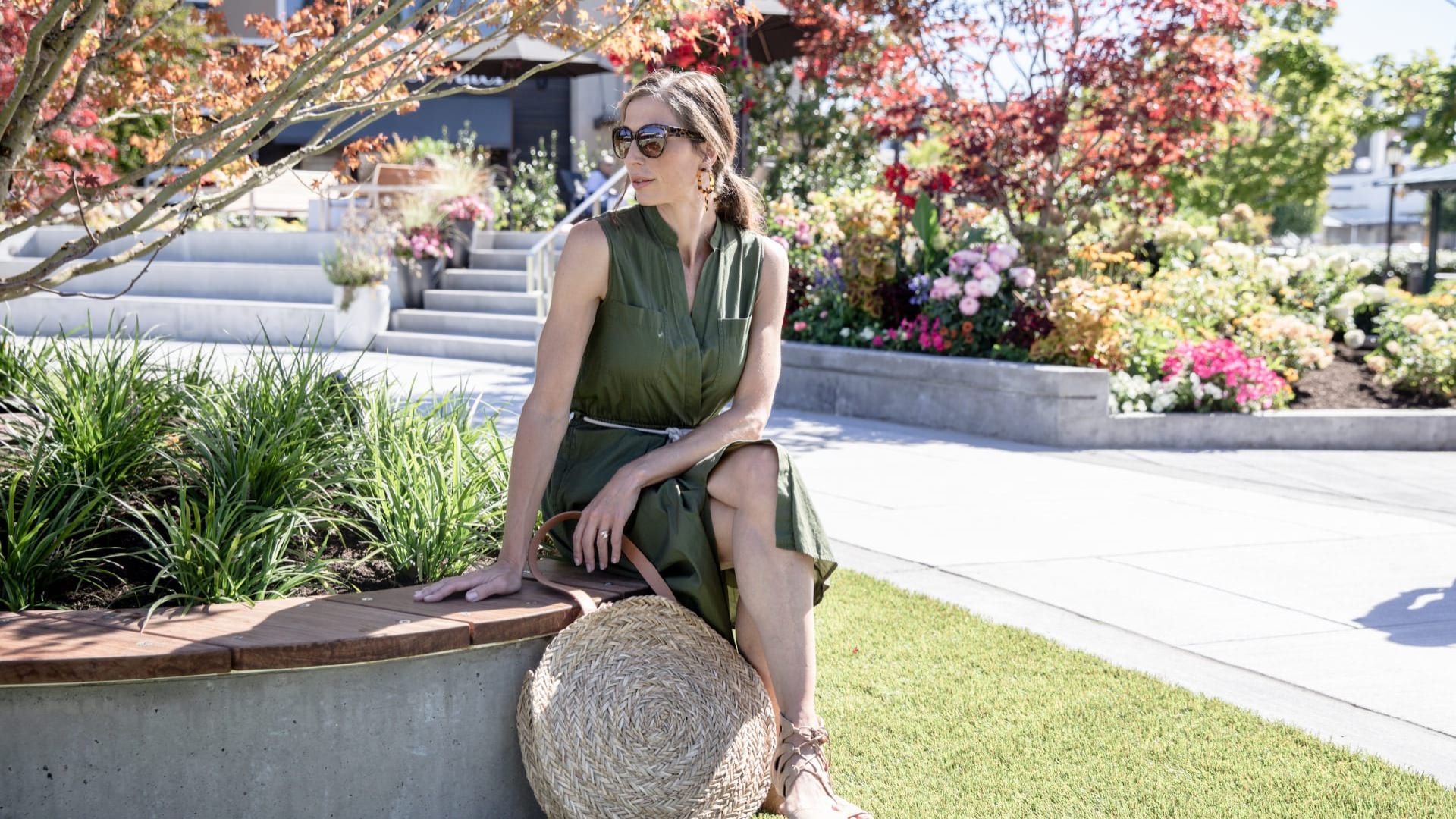 Woman sitting in the sun around lush landscaping